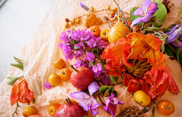 Beautiful still life with fruit, seeds, flowers and leaves on the light table