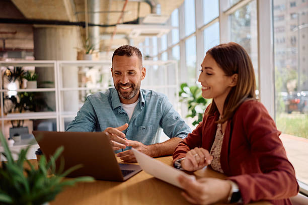 istock Happy colleagues cooperating while working on laptop in the office. 2219850923