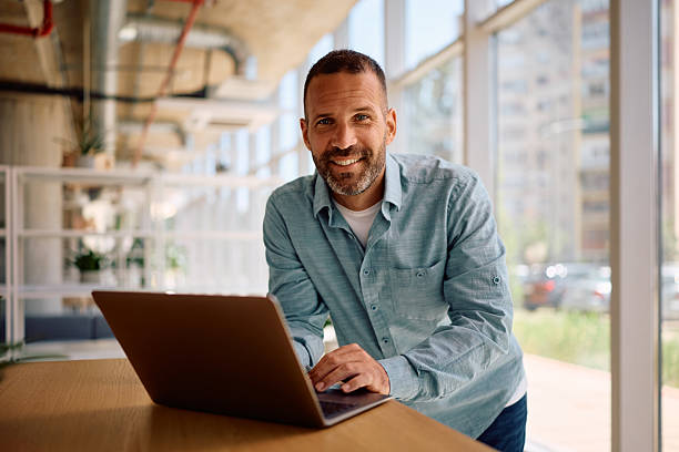 istock Happy entrepreneur working on laptop in the office and looking at camera. 2219850924