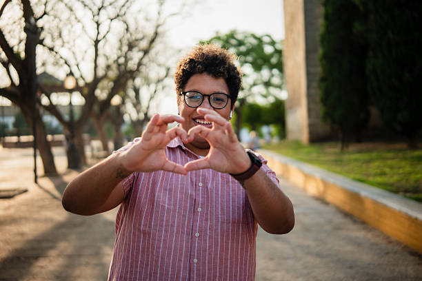 istock Young man making heart shape with hands in a park 2219856170