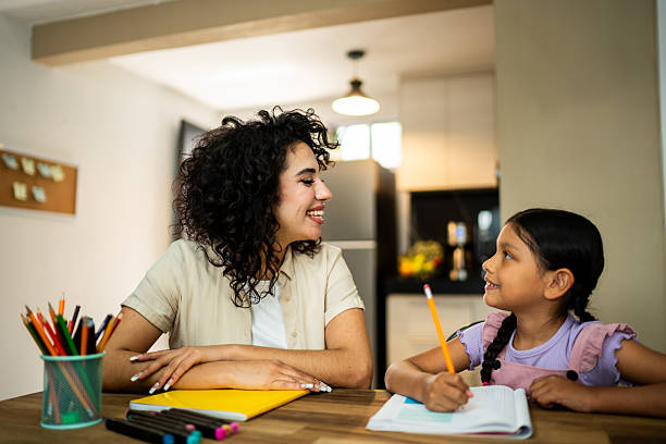 istock Young mother helping daughter with home work 2219857814