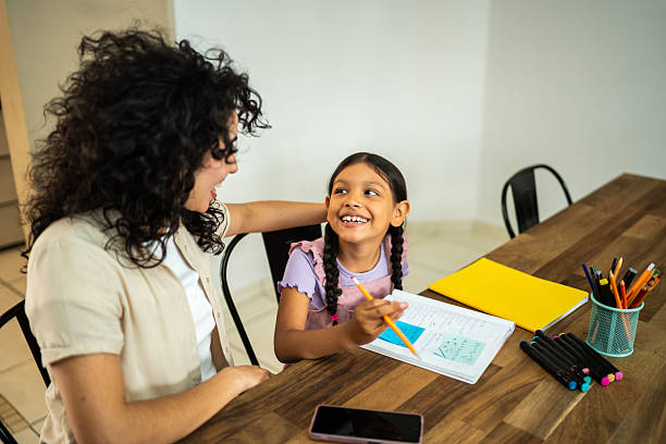 istock Young mother helping daughter with home work 2219857818