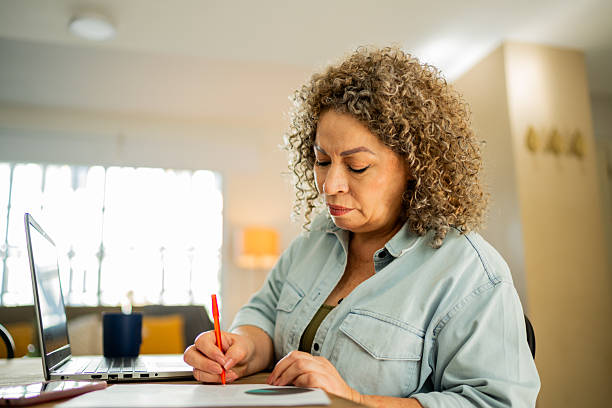 istock Senior woman doing home finances using laptop at home 2219857938