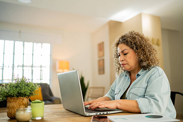 istock Senior woman doing home finances using laptop at home 2219857940