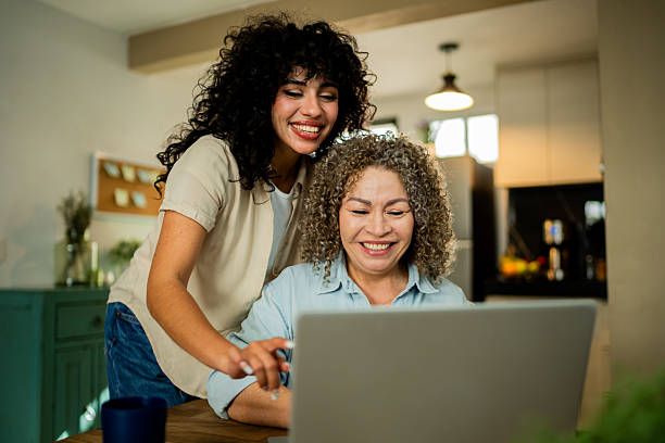 istock Young daughter talking to mother while she using laptop at home 2219857971