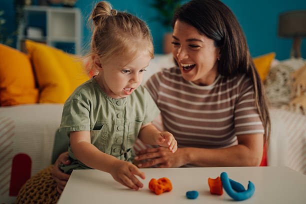 istock Mother and daughter playing with modeling clay at home 2219858316