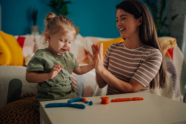istock Mother and daughter playing with modeling clay at home 2219858325