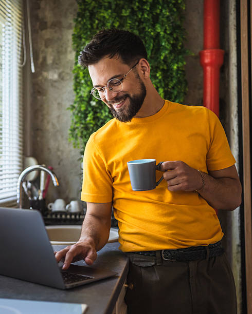 istock relax adult man drink coffee and use laptop computer in the kitchen 2219859578