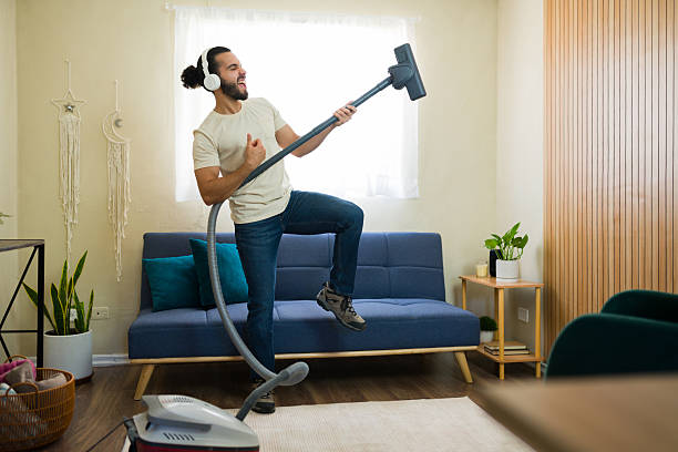 istock Full length view of a man having fun while vacuuming at home 2219861114