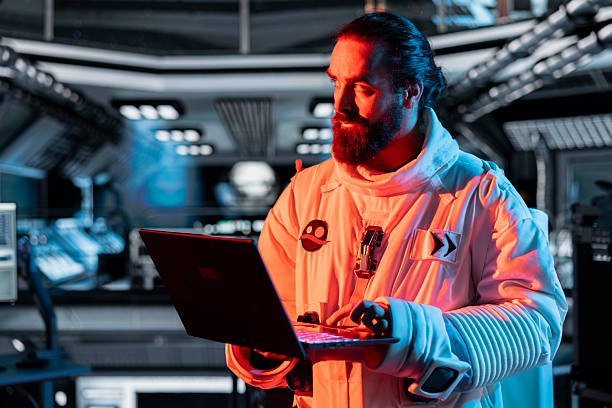 istock Cosmonaut works on laptop to troubleshoot red light warning system error 2219862481