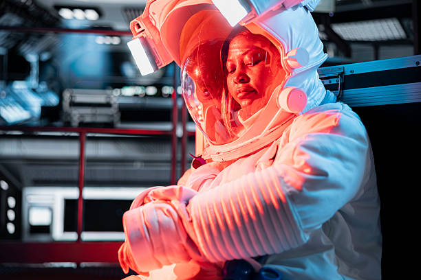 Woman in malfunctioning starship activates onboard backup systems. Female astronaut pressing wrist touchscreen display to take protective measures, alerted by emergency red lighting