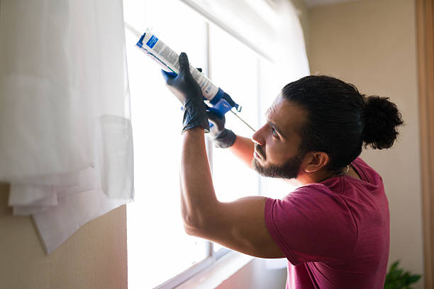 istock Man applying silicone sealant to window frame at home 2219863403