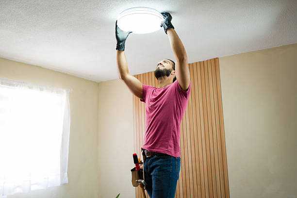 istock Handyman installing ceiling light fixture in residential home 2219863470