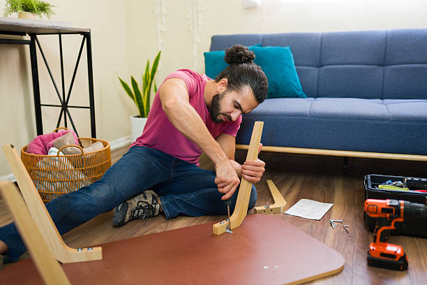 istock Handyman concentrating on assembling furniture at home 2219863694