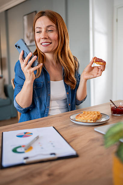 istock Businesswoman having breakfast and using smartphone 2219864181