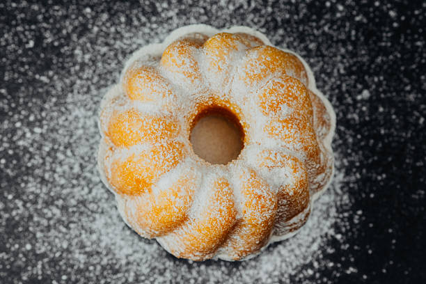 Bundt cake with powdered sugar on black background