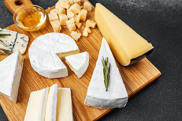 istock Various cheeses and honey on a wooden serving board in a kitchen setting 2219866490