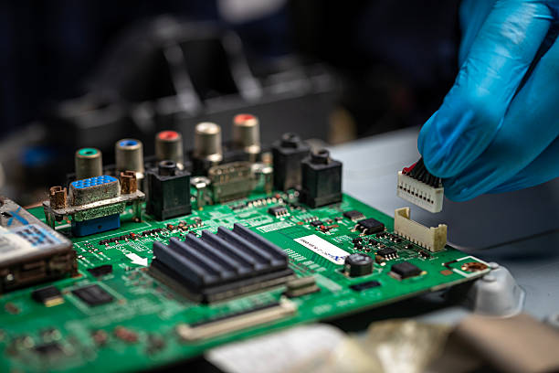 istock Repairman fixing an LCD TV circuit board on table. Close up, electronic device 2219868003