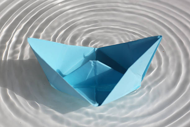 istock Paper boat floating on rippling water 2219870812