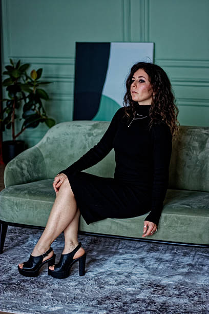 istock Young woman sitting on the green sofa 2219871688