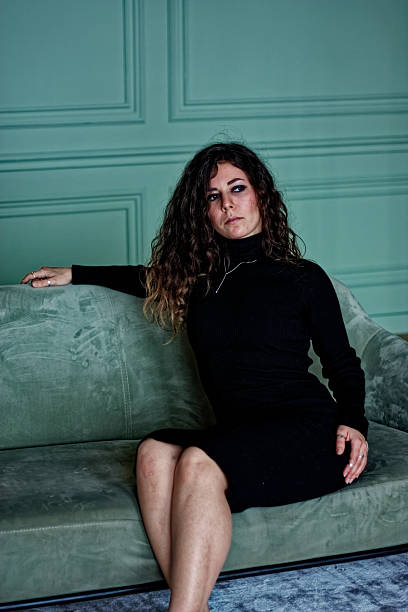 istock Young woman sitting on the green sofa 2219871700