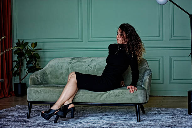 istock Young woman sitting on the green sofa 2219871717