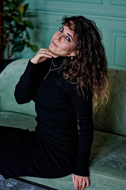 istock Young woman sitting on the green sofa 2219871785