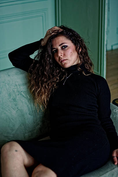 istock Young woman sitting on the green sofa 2219871791