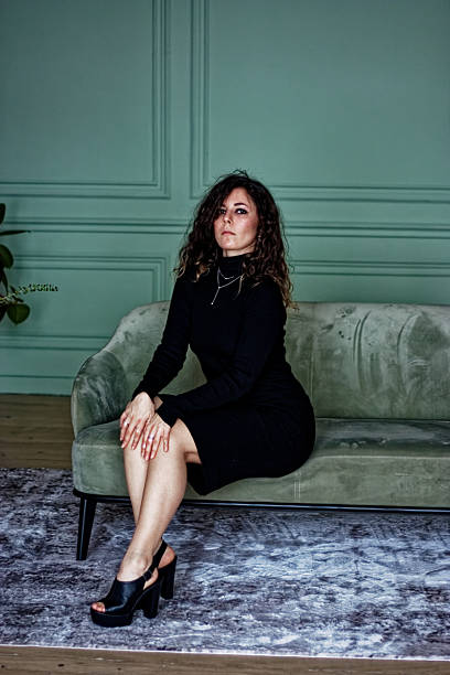 istock Young woman sitting on the green sofa 2219871994