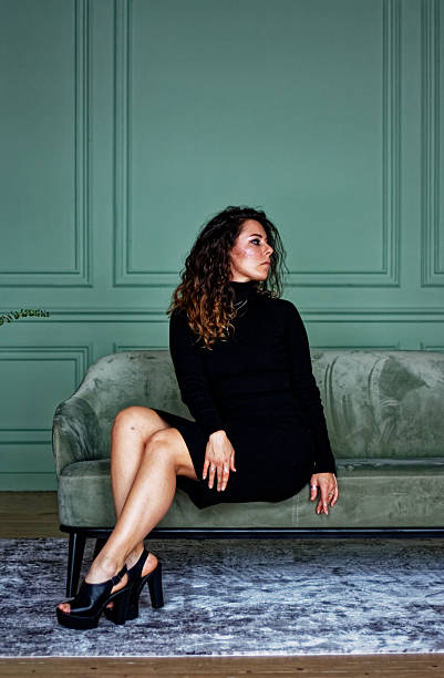 istock Young woman sitting on the green sofa 2219871995