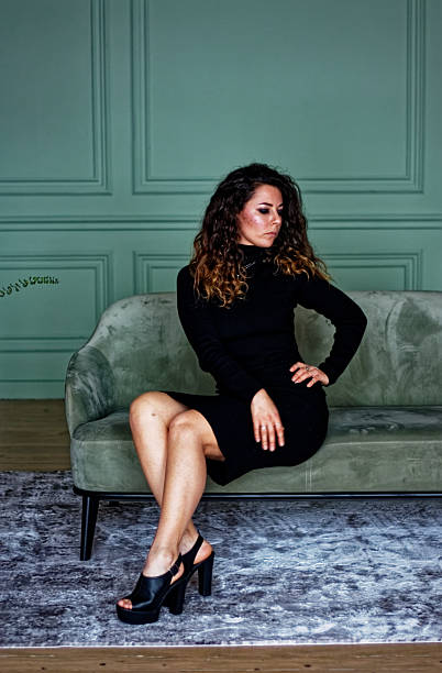 istock Young woman sitting on the green sofa 2219871997
