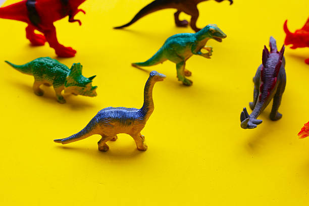 istock Plastic dinosaur toys on yellow background 2219873716