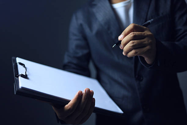 istock A businessman writing on clipboard 2219876024