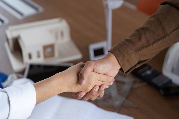istock Collaborative Efforts in ESG. Close-up of architects shaking hands on a project. 2219877469