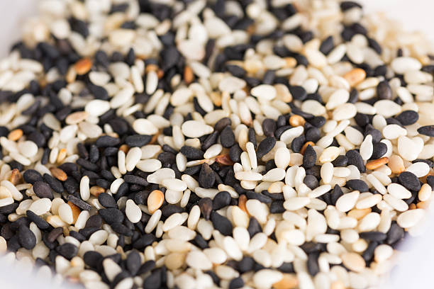 white and black sesame seeds mixed in a pot background