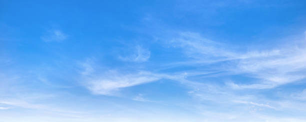 istock sky is blue and clear with clouds. The sun is shining brightly, making the sky look even brighter. Scene is peaceful and serene 2219889715
