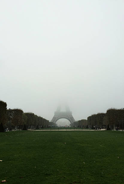 Eiffel Tower partially obscured by dense fog in Paris.