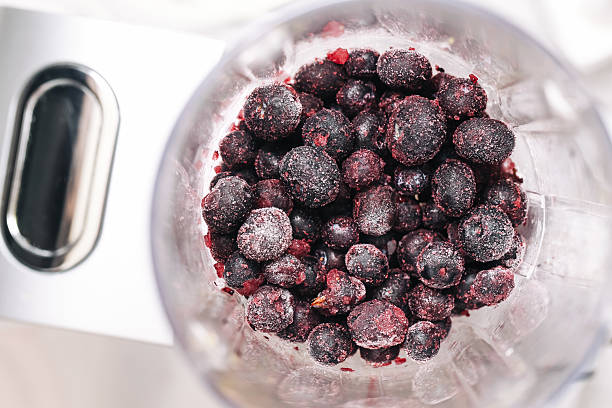 istock Frozen blueberries in blender. Dark purple fruit close-up. Cold smoothie ingredients. 2219892079