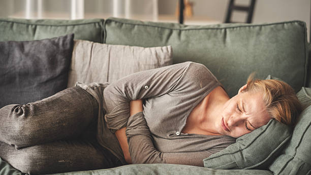 istock Young woman with stomach ache 2219893336