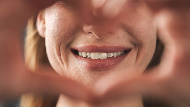 istock Woman smiling and making heart shape with her hands 2219893341