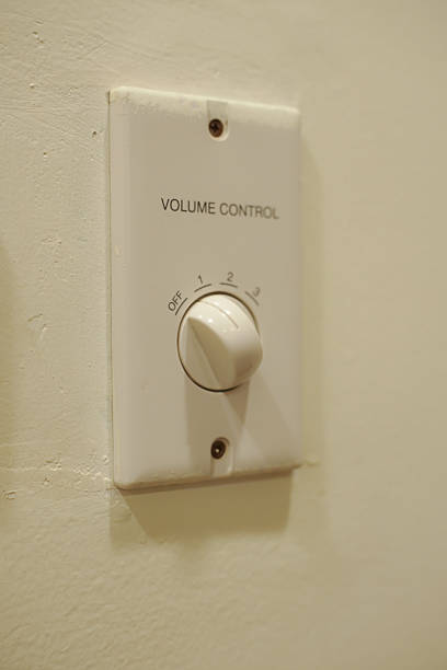 istock hand turns on the fan control panel on the wall. 2219896946