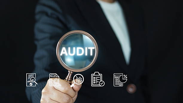 istock Businessman performing financial audit with magnifying glass on digital dashboard using virtual interface, showcasing data analysis, compliance, and corporate risk management. 2219900012