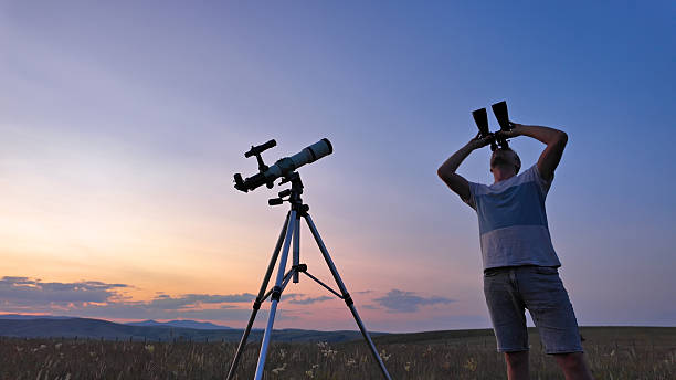 istock Amateur astronomer using telescope and binoculars for watching stars, Moon, planets and other celestial objects from a countryside field in nature. 2219904250