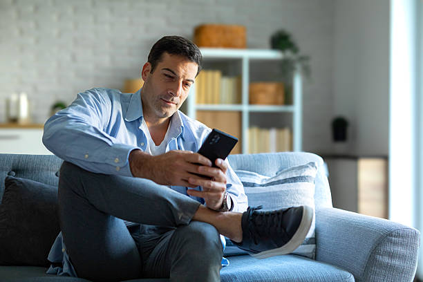istock Modern Man Using Smartphone in Cozy Living Room 2219904472