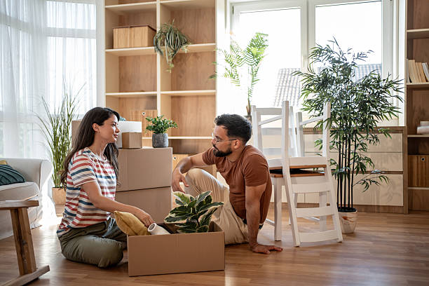 istock Young couple unpacking boxes in new apartment, taking a break 2219904538