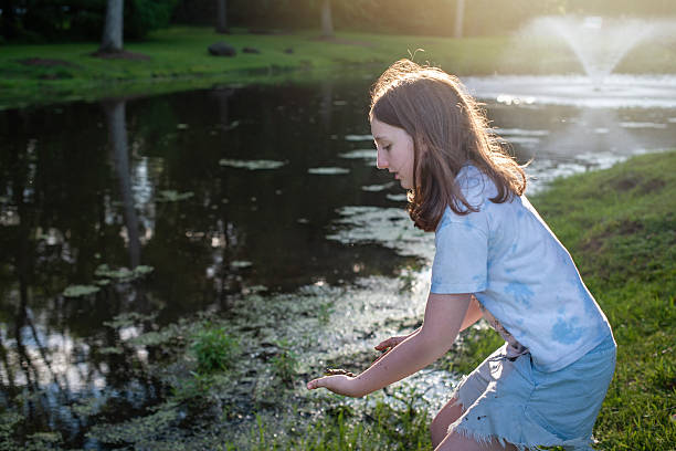 istock Nature study at pond edge. 11-year-old student examines water samples during summer science project. 2219905044
