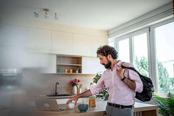 istock Businessman leaving home after checking laptop in kitchen 2219906017