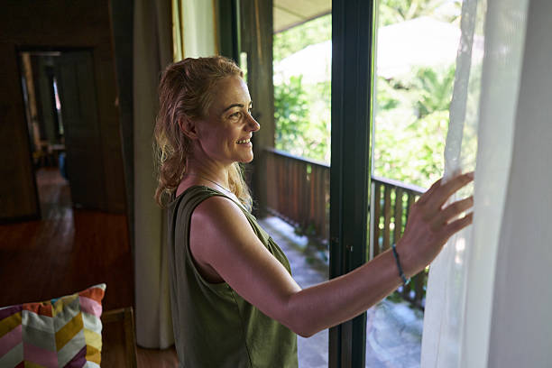 istock Happy woman day dreaming through window at home. 2219911775