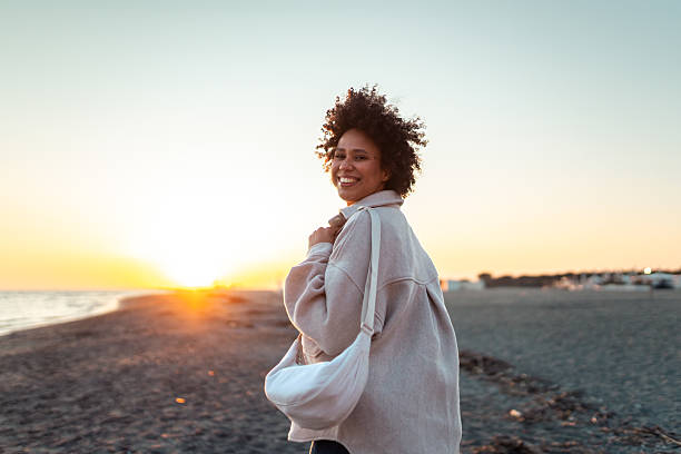 istock Smiling Multiracial Woman Enjoying Sunset Stroll on Serene Beach 2219914319