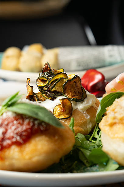 istock Fried pizzas with sausages, cheese, tomato and vegetables on a table at the restaurant 2219914905